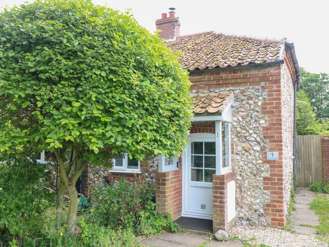 A cottage exterior with a tree and a pathway at Broom Cottage in East Rudham near Fakenham