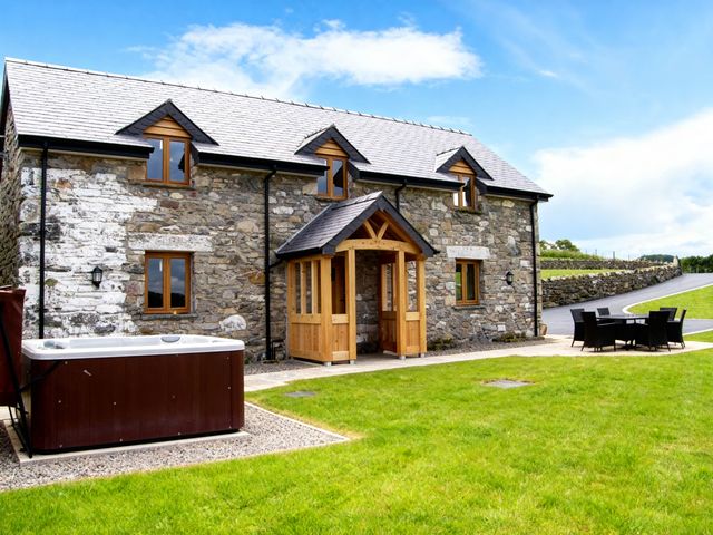 A house with a hot tub and patio furniture at Tyn Y Celyn Canol Clocaenog near Ruthin