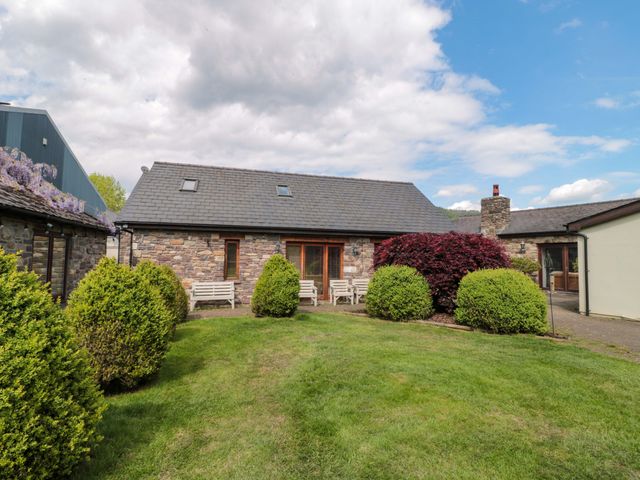 A garden with seating and greenery at Riverside Barn Gilwern near Crickhowell and Abergavenny