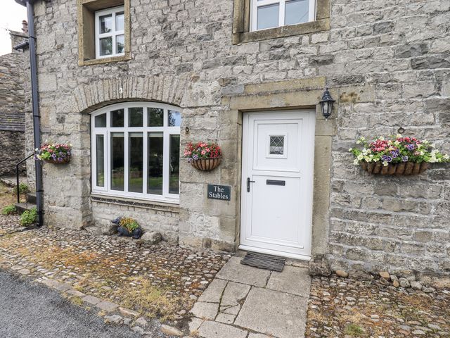 An entrance with flower baskets and a sign at The Stables in Horton-in-Ribblesdale near Settle