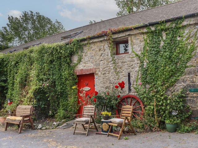 An outdoor area with a stone wall and garden furniture at Mrs Delaney's Loft Ardfinnan near Clonmel County Tipperary