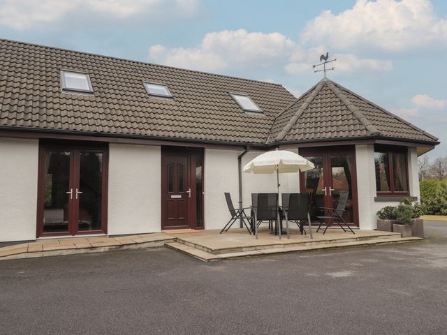 An outdoor area with a table and chairs at Little Chestnut in Muir of Ord