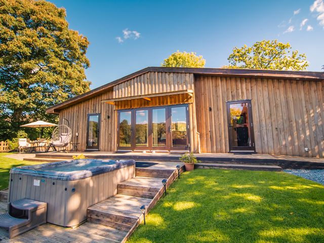 An outdoor area with a hot tub and seating at Sycamore Lodge Nantmel near Rhayader