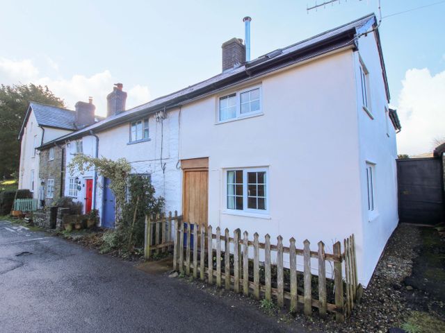 A house with a red door and white walls at Marigold Cottage in Clun near Bishop's Castle