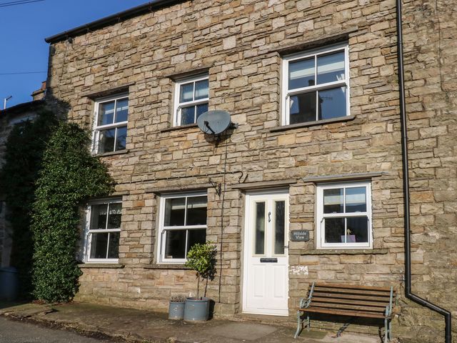 An exterior view of a stone house with a bench and plants at Hillside View in Hawes