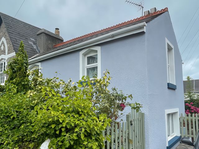 A house with a garden and fence at Little Acre in Torquay