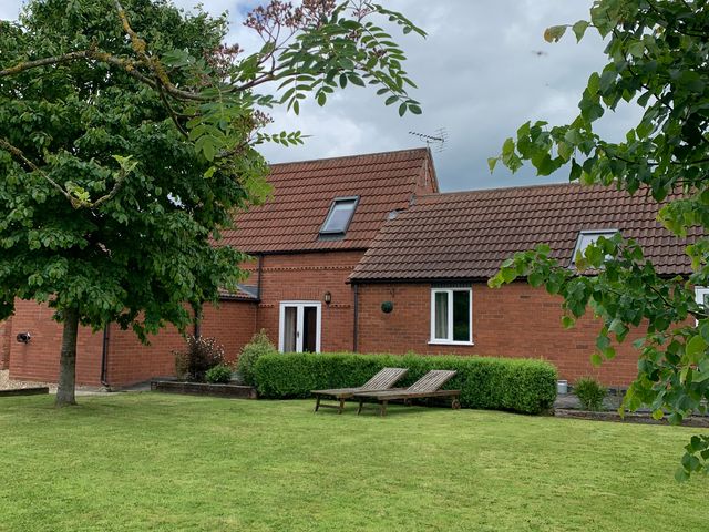 A house with lawn and deck chairs at The Barn Ivy Cottage Kexby near York
