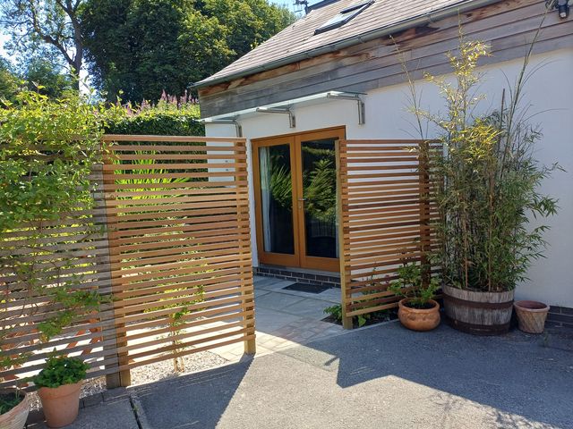 An outdoor area with a wooden fence and potted plants at The Sidings in Wirksworth