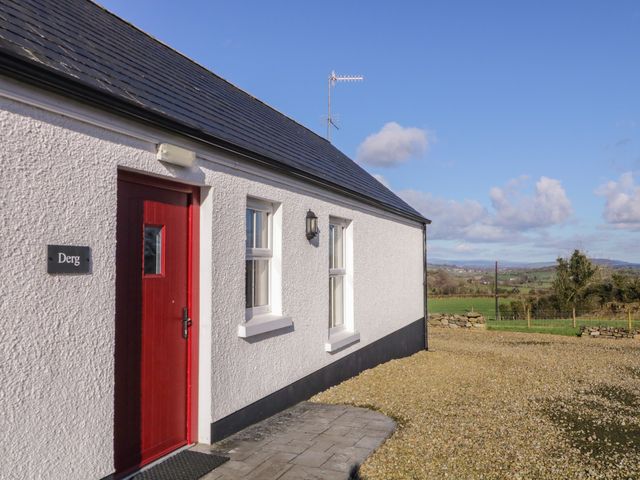 Exterior view of a white cottage with red door at Derg Cottage in 