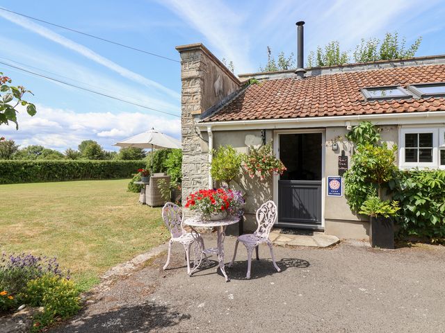 An outdoor area with a table and chairs at Pear Tree Cottage Mark near Burnham-on-Sea