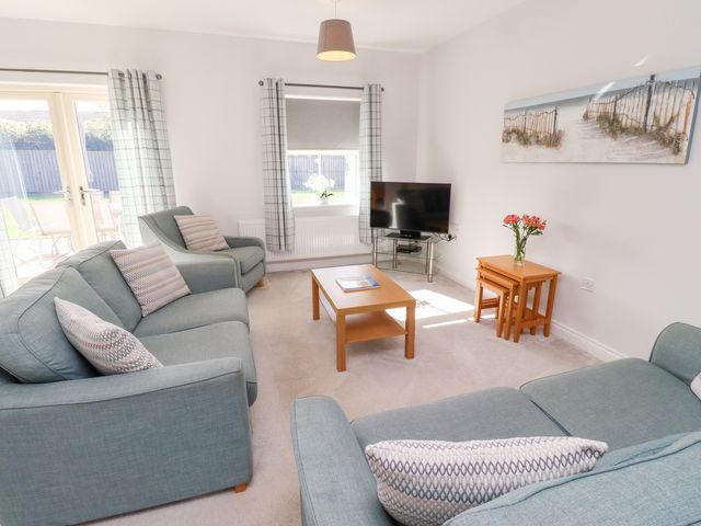 A living room with a television and seating area at The Haven in Embleton
