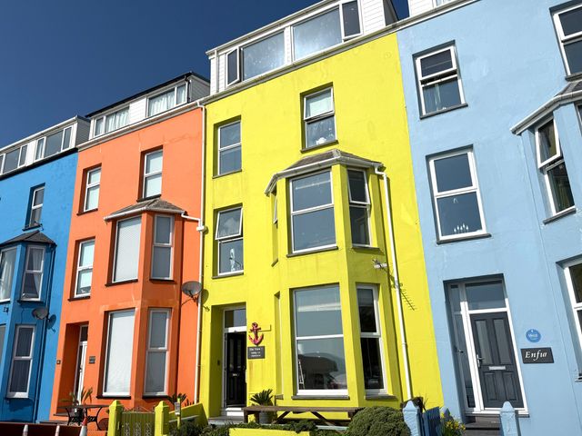 A row of colorful buildings with windows and doors at The View in Criccieth