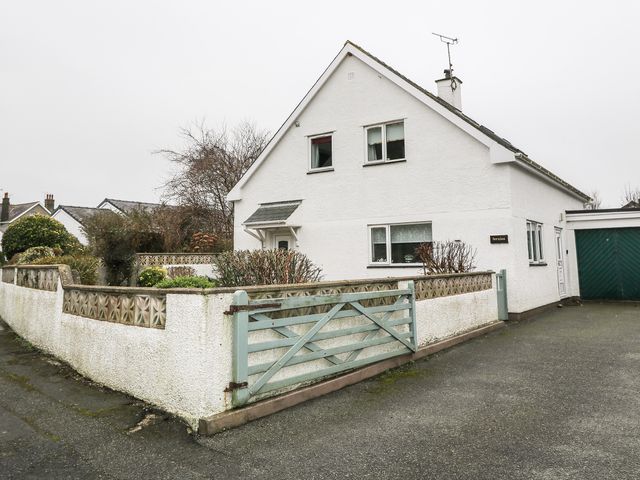 A white house with a green wooden gate and a small garden surrounded by a white wall at Fernlea in Morfa Nefyn