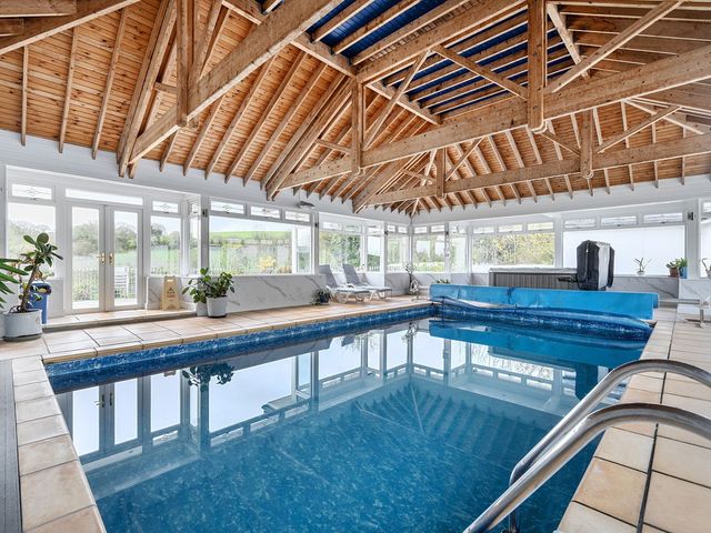 An indoor pool area with spa amenities at Chapel Green Studio Polgooth near St Austell