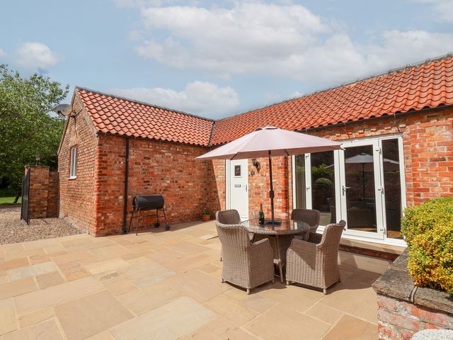 An outdoor seating area with a table and chairs at Winsall Court I Gransmoor near Bridlington