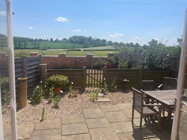 A garden with a table and chairs at Stables Cottage in Uppingham