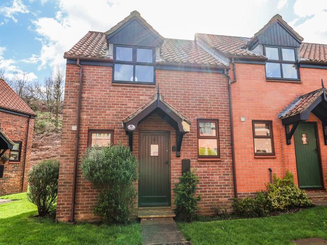 A house with a green door and windows at Waterside Cottage in Whitby