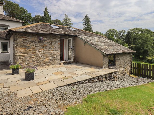 An outdoor area with a stone wall and patio at Acorn in Bowness-on-Windermere