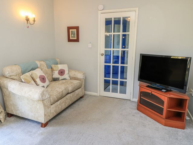 A living room with a sofa and a television at Lamora in Cheddar