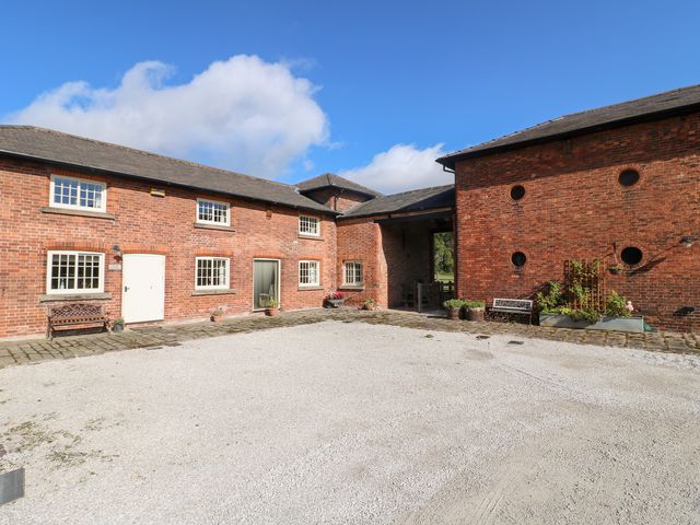 An outdoor courtyard with brick buildings and benches at The Dairy in Eastwood
