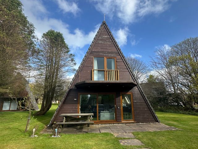 A house with a balcony and patio furniture at Lodge 22, Bodmin Holiday Park, Cornwall