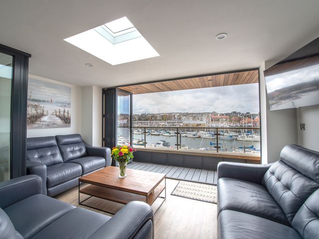 A living room with a view of the marina at Harbour Sunset