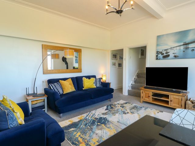 A living room with a sofa and television at Little Orme View in Llandudno