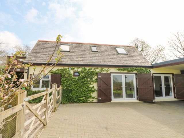 Exterior of a house with wooden shutters and climbing plants on the walls at Higher Kernick Stable in Helland near Blisland