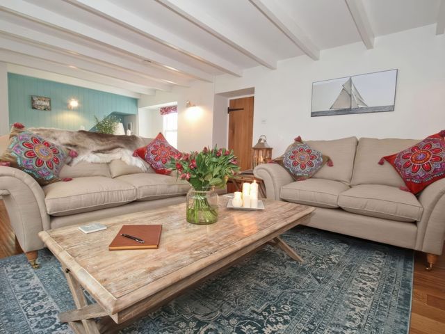 A living room with sofas and a coffee table at Trelan in Mevagissey