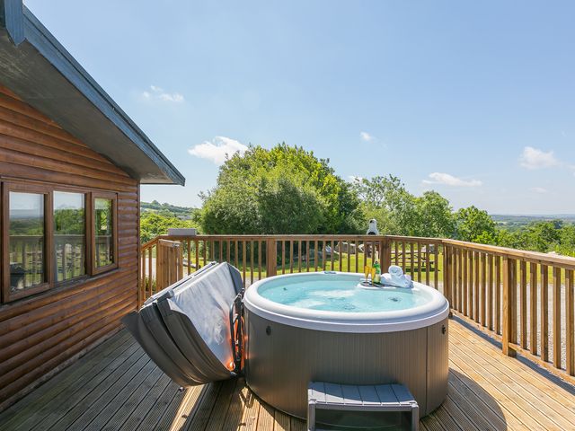 A hot tub on a deck with a view at Costentyn, Tor Down Quarry, St Breward