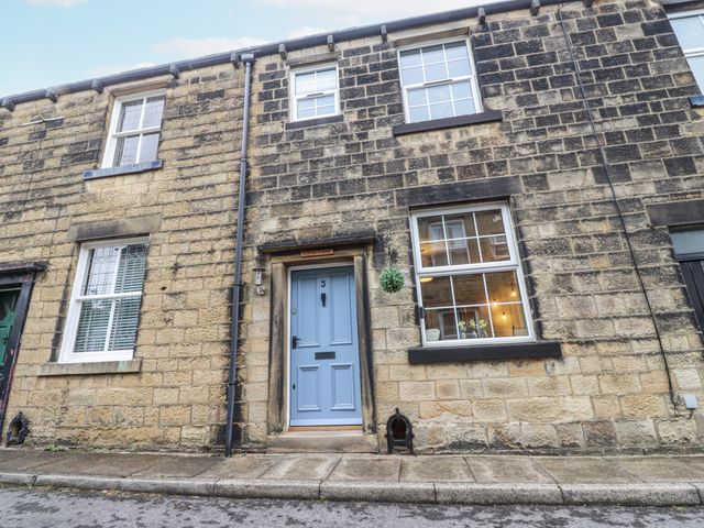 A front view of a house with a blue door and windows at Lorna Loom in Skipton