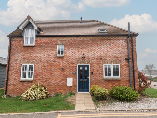 A brick house with a blue front door at Coastal Cottage The Bay near Filey