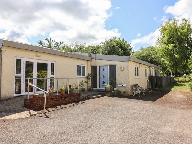 An outdoor area with a house, plants, and pathway at Brookfield Lodge in Drimpton