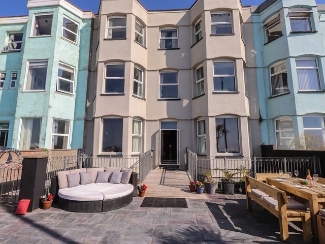 An outdoor area with seating and a dining table at Wavecrest in Pwllheli