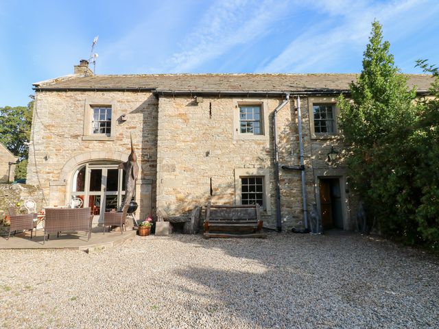 An outdoor area with a stone house and seating at 2 The Coach House, Romaldkirk near Middleton-in-Teesdale