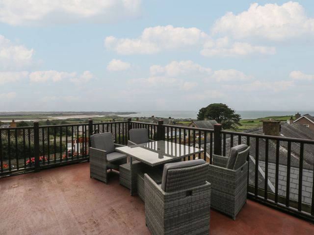 An outdoor terrace with a table and chairs overlooking the sea at Maesawel Studio Llanfair