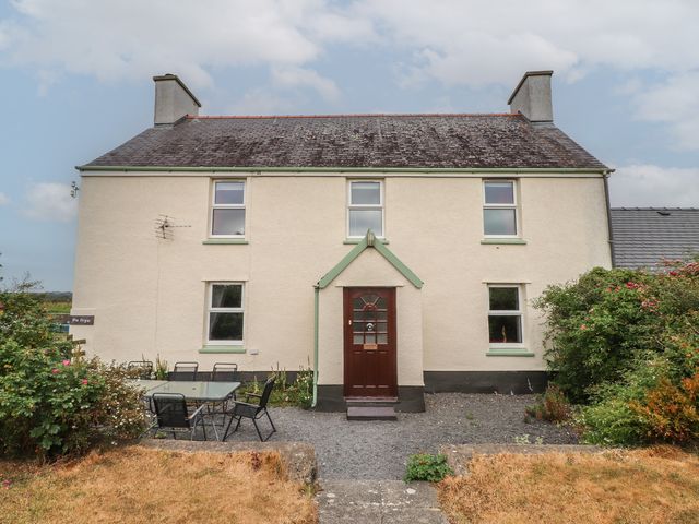 A house with a door and windows and outdoor seating at The Bryn in Brynsiencyn near Newborough