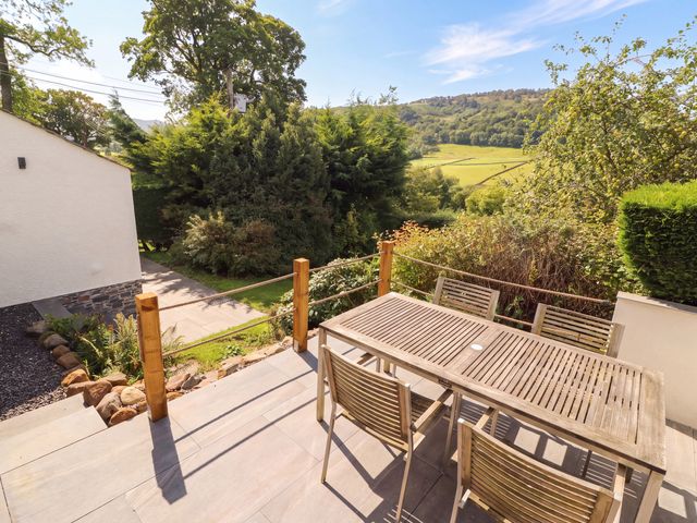 An outdoor area with a wooden table and chairs at Mell View Cottage Ullswater