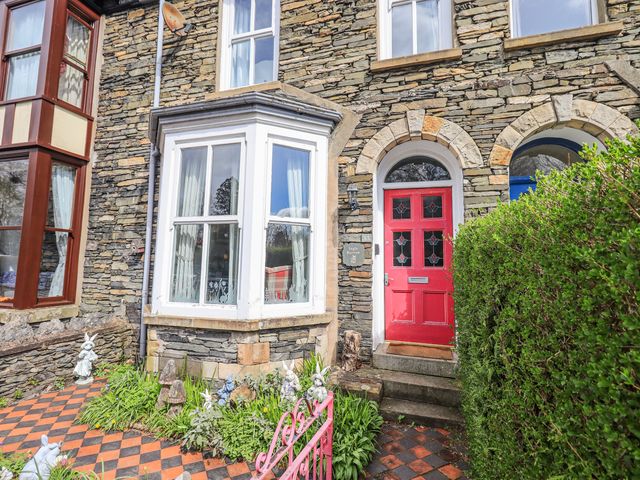 An exterior view of a stone house with a red door at Ingle Burrow Windermere