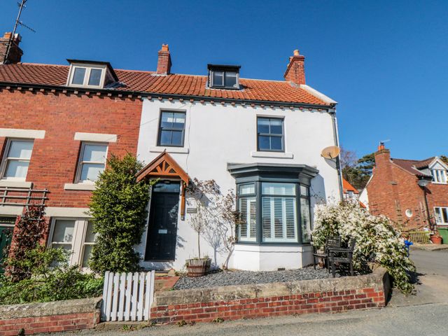 A house with a front door and windows at Harriet's Cottage in Briggswath