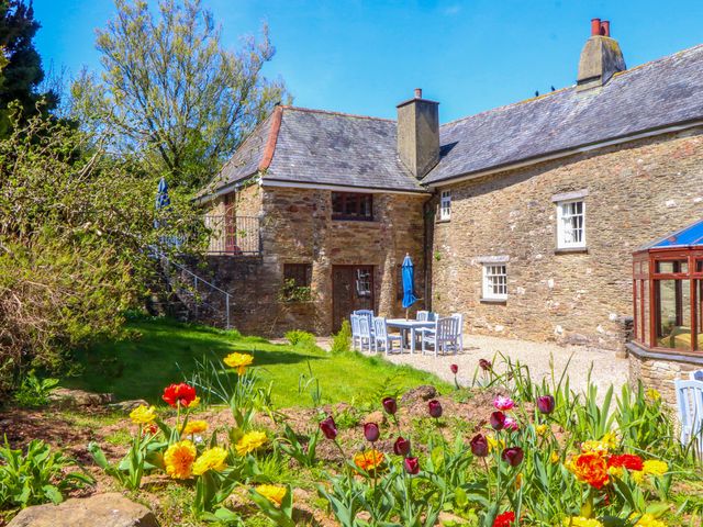 A garden with flowers, table and chairs at East Bickleigh in Halwell