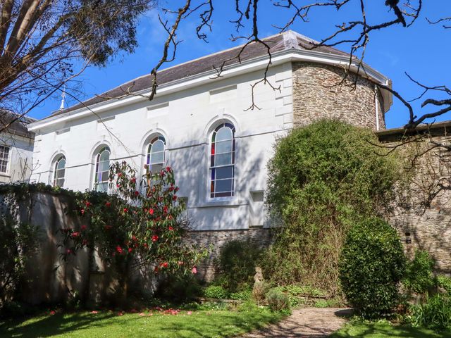 A garden with a building and plants at The Music Room near Aveton Gifford