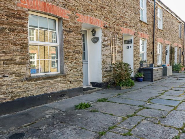 A stone building with a door and windows at Kingfisher Cottage in Edmonton, near Wadebridge
