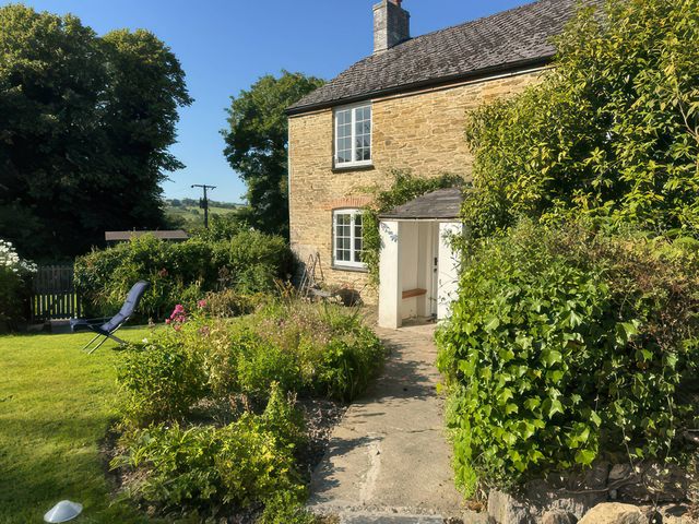 A garden view with a pathway and seating area at Kingbarth in Lerryn
