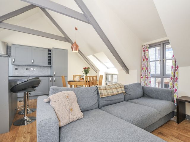 A living room with a sofa and dining area at Beach Retreat in Looe