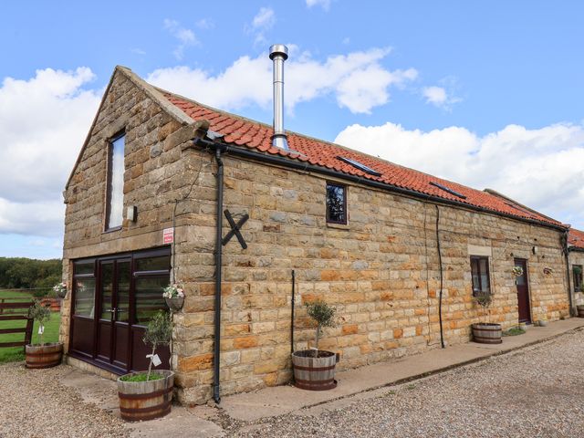 An exterior view of a stone building with a chimney at Hayloft in Staintondale