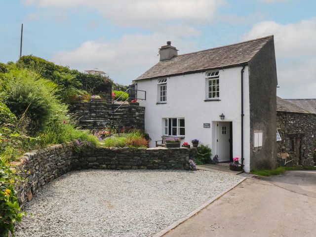 A house with gravel area and stone wall at Rose Cottage in Broughton-In-Furness