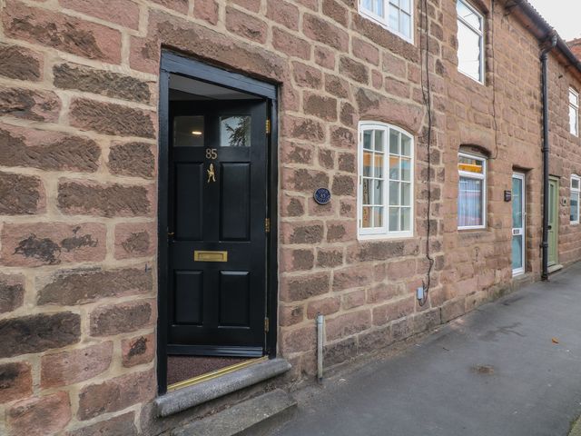 An entryway with a black door and stone wall at The Hill in Cromford