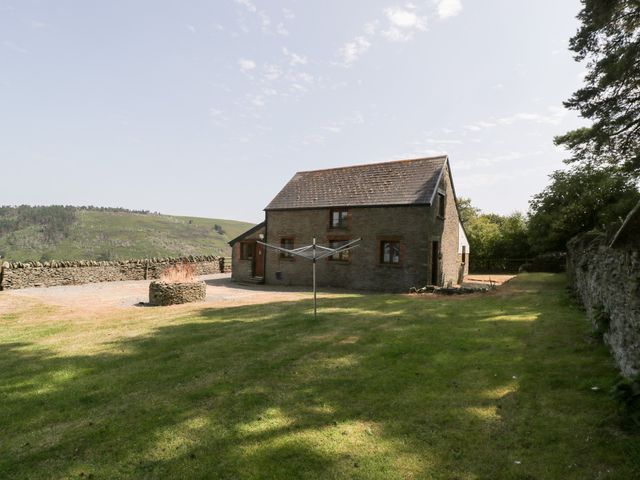 A house with a clothesline and grass area at Penrhiwarwydd Barn, Pontywaun