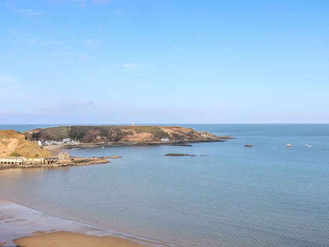 A coastal view with a bay beach hills and buildings near water at Tan Y Goeden in Morfa Nefyn